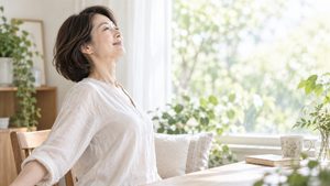 窓辺で深呼吸する女性